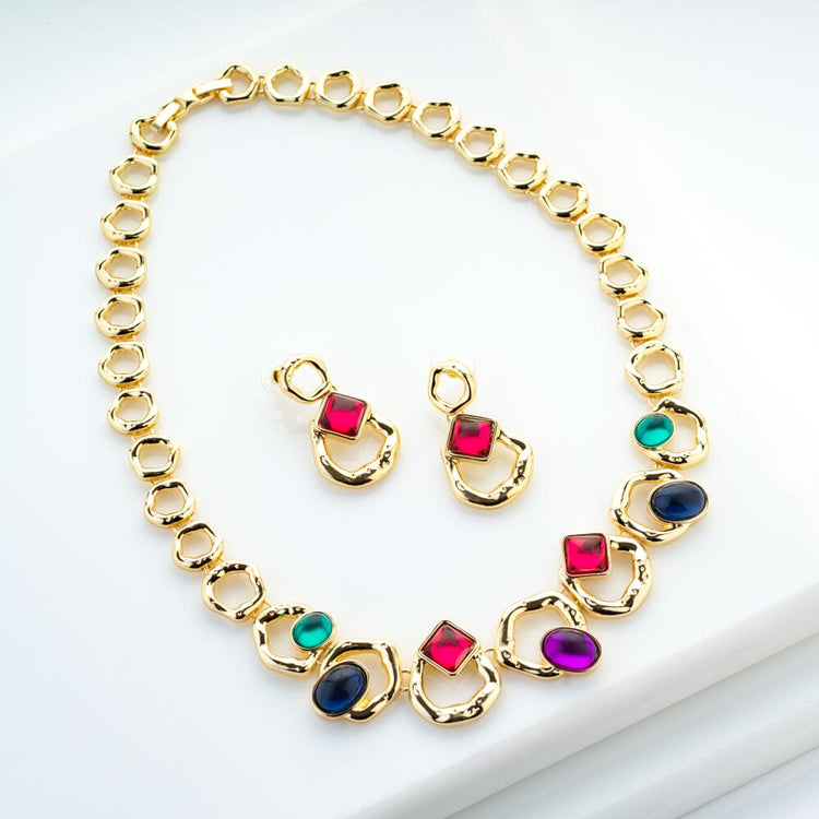 Lot - Jomaz 1960s gold tone bib statement necklace ruby red glass cabochon  on openwork brutalist modern 'rays'.
